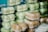 Several stacks of clear plastic containers filled with food items, with some of the containers holding light green items and others holding brown baked goods.