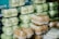 Several stacks of clear plastic containers filled with food items, with some of the containers holding light green items and others holding brown baked goods.