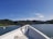 A scenic view of a boat gliding through clear blue waters surrounded by lush greenery.