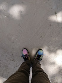 Close-up of colorful dance shoes on sandy beach with pink and blue hues