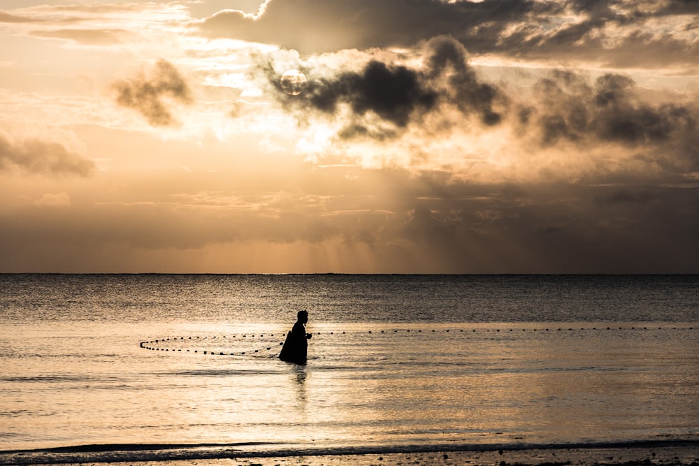 person on ocean during sunrise