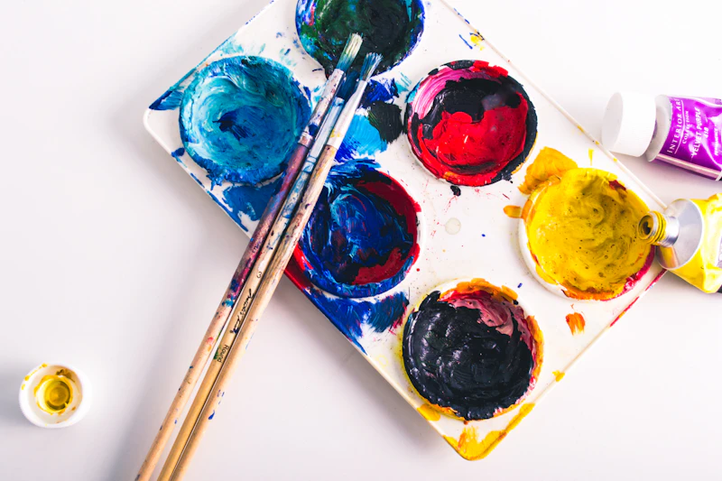 Three paintbrushes on a colourful palette
