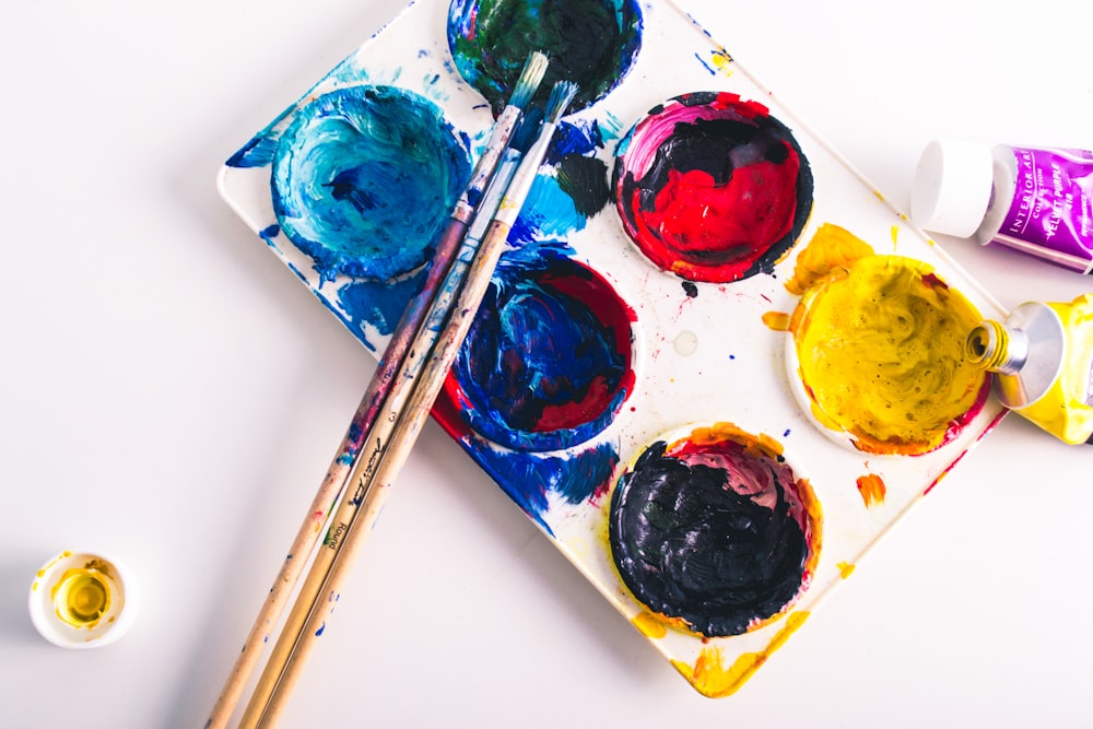 brown paint brushes on assorted-color paint palette