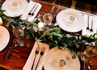 white ceramic dinner plate set on brown wooden table