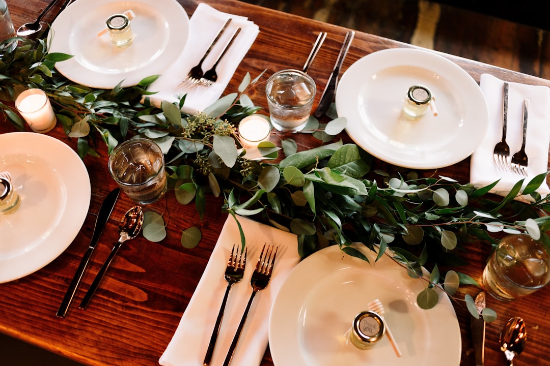 white ceramic dinner plate set on brown wooden table,