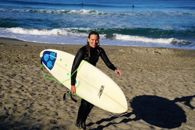 woman holding surfboard standing on sea shore seaside zoom background