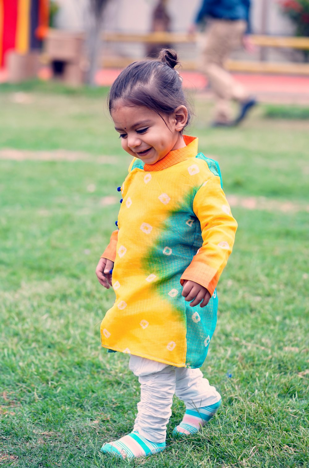 girl smiling looking down on grass