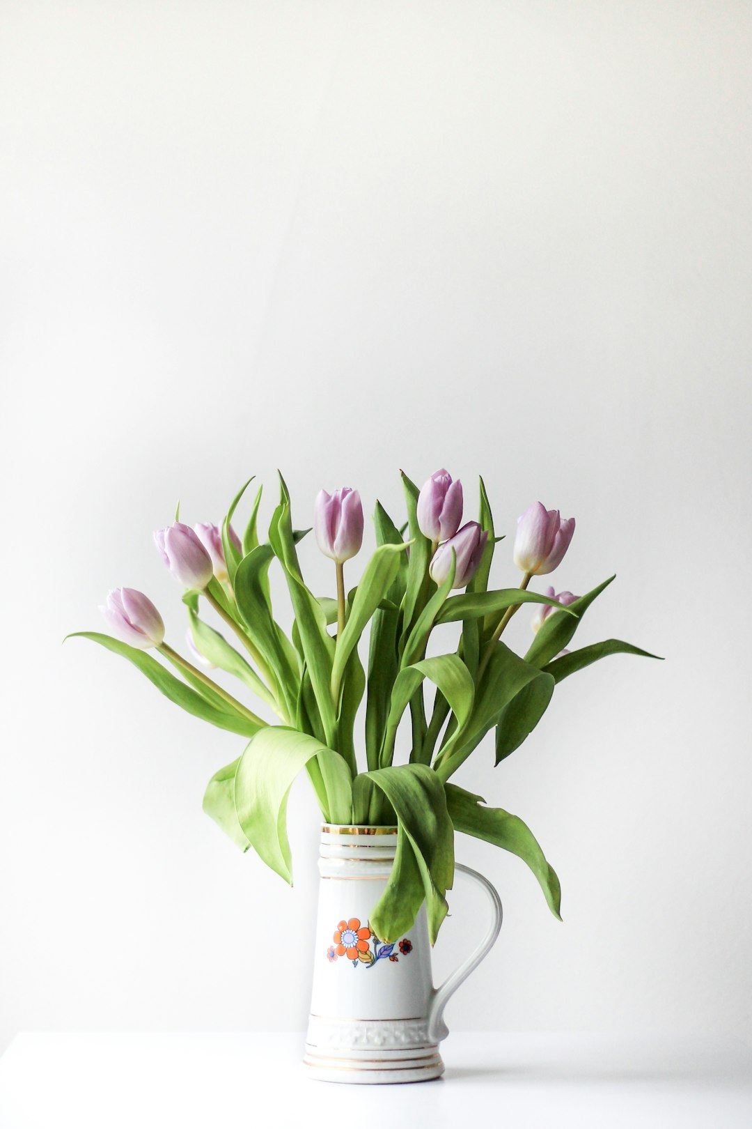 selective focus photography of purple tulip flower arrangement