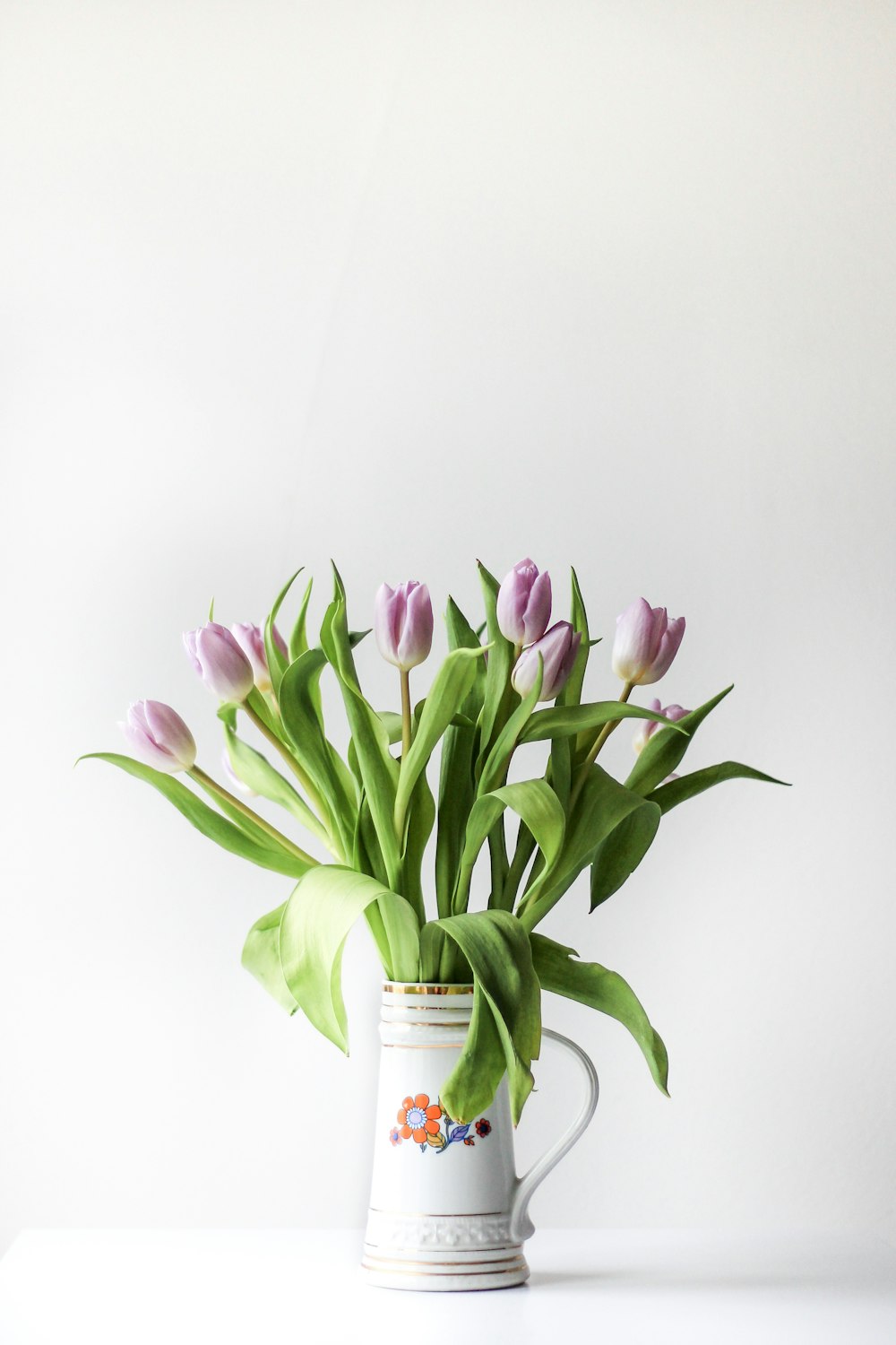 selective focus photography of purple tulip flower arrangement