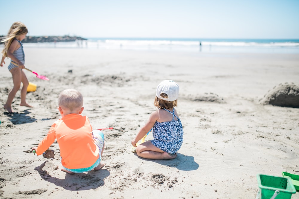 three children playing at the beach