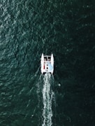 people riding on pontoon boat on body of water during daytime