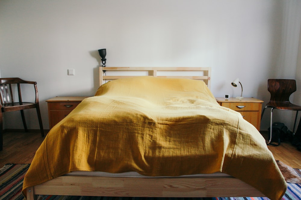 a bed with a yellow comforter in a bedroom