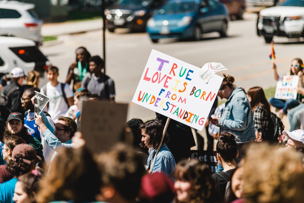 people holding signage rallying outdoor