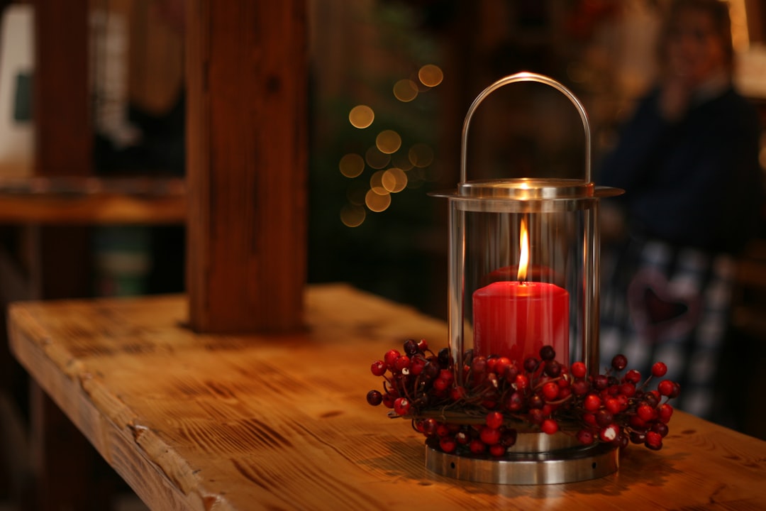 red lighted candle on brown wooden frame,