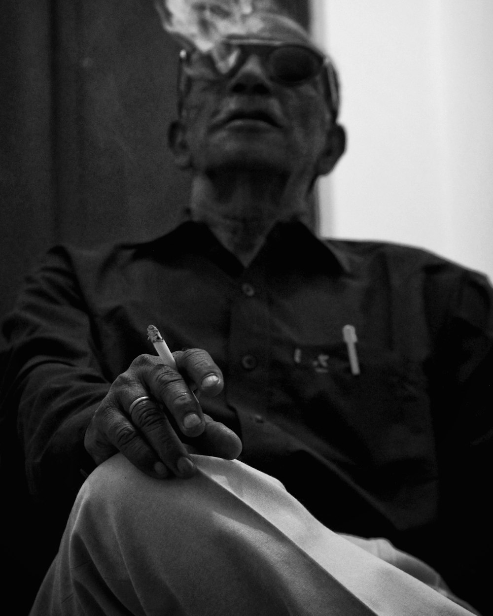 grayscale photo of man smoking cigarette