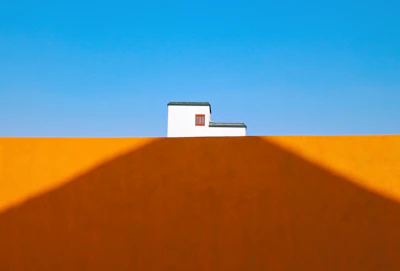 Minimalist composition of colorful street art on a simple wall, emphasizing texture and contrast.