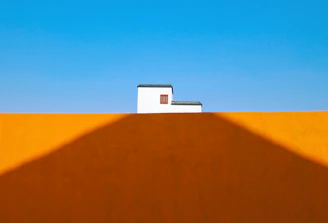 Minimalist composition of colorful street art on a simple wall, emphasizing texture and contrast.