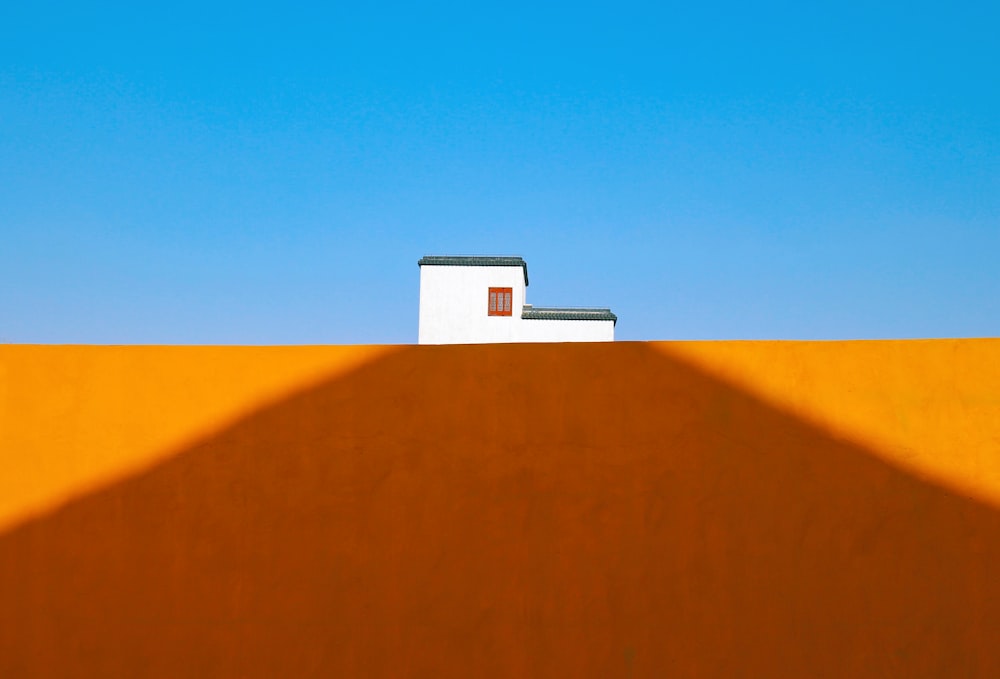 Una casa sulla cima di una collina con un cielo blu sullo sfondo