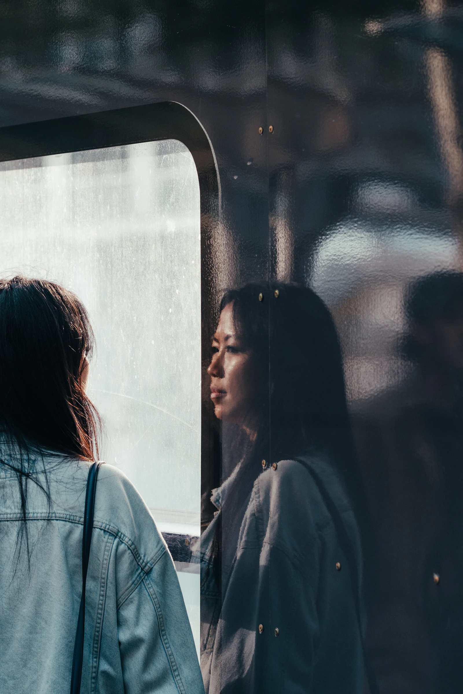 Woman looking at her reflection in a window, representing self-doubt and questioning what happened in a relationship