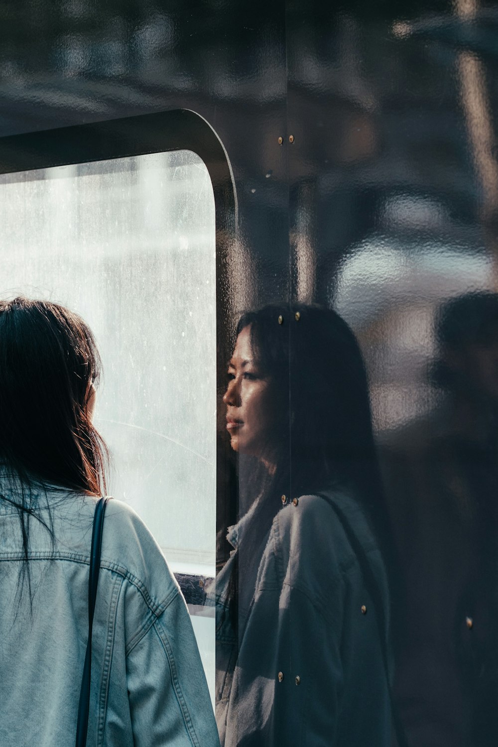 woman looking at window at his reflection