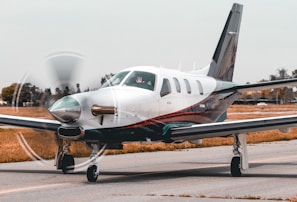 white and gray monoplane on runway at day time