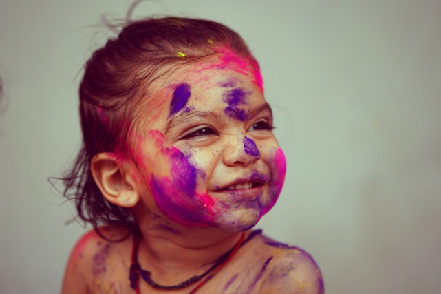 A joyful child engaged in a colorful art therapy session