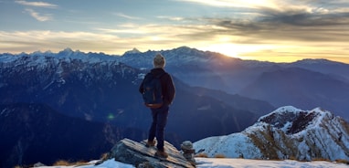 person standing on top of the mountain facing sunrise