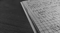 A close-up of handwritten notes and sketches on graph paper.