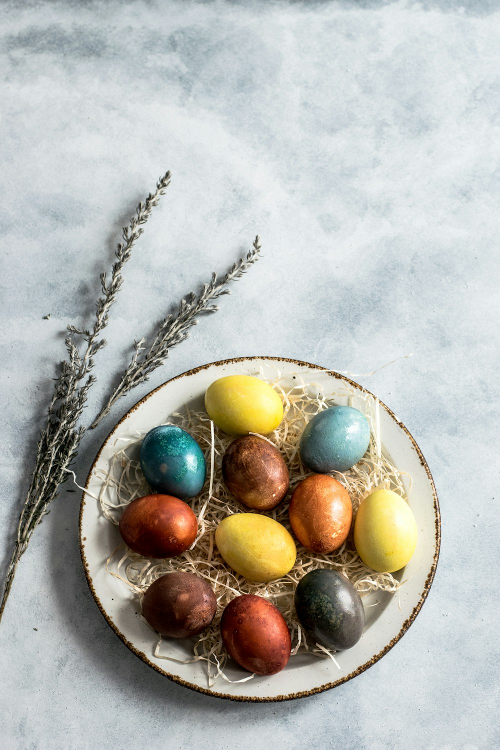 Huevos de colores variados en bandeja de cerámica blanca