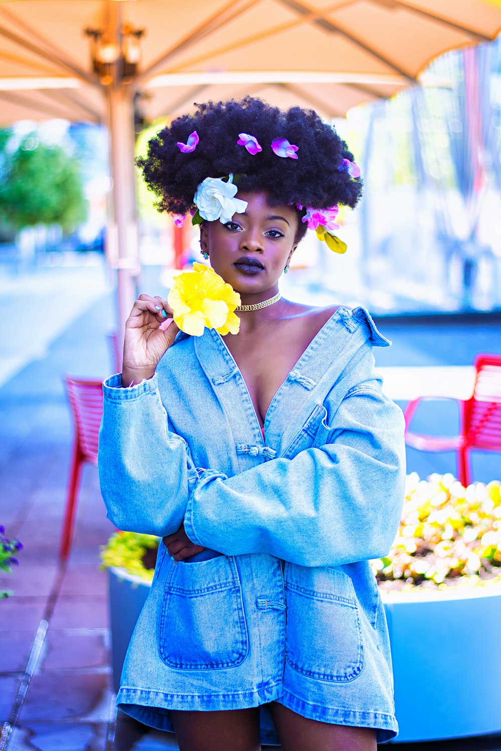 Mujer con chaqueta de mezclilla azul con flores en el cabello