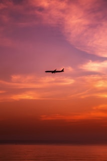 A scenic airplane taking off against a vibrant sunset sky