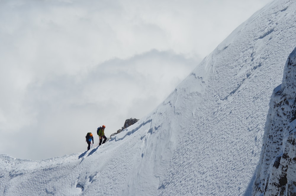 two persons trekking on snow mountain