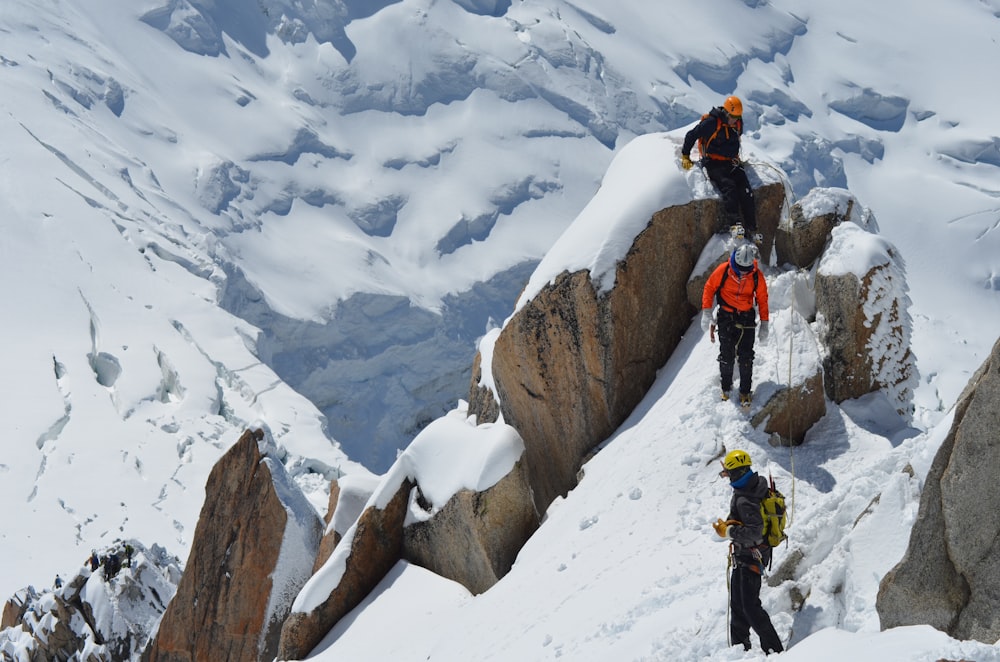 Trekking de três pessoas na montanha do campo de neve durante o dia
