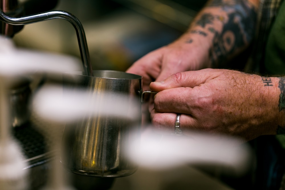 person holding stainless steel mug