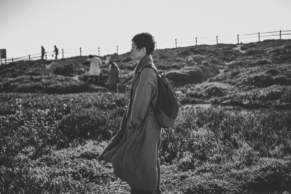 grayscale photo of person standing on hill