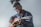 smiling man sitting while playing guitar