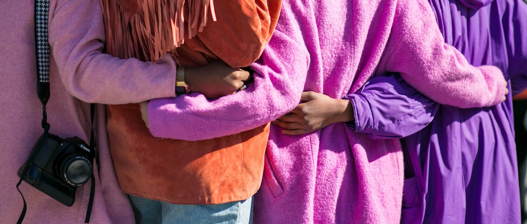 four person holding each others waist at daytime