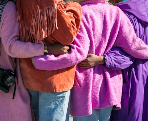 four person holding each others waist at daytime