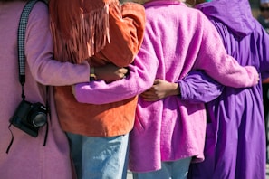 four person holding each others waist at daytime