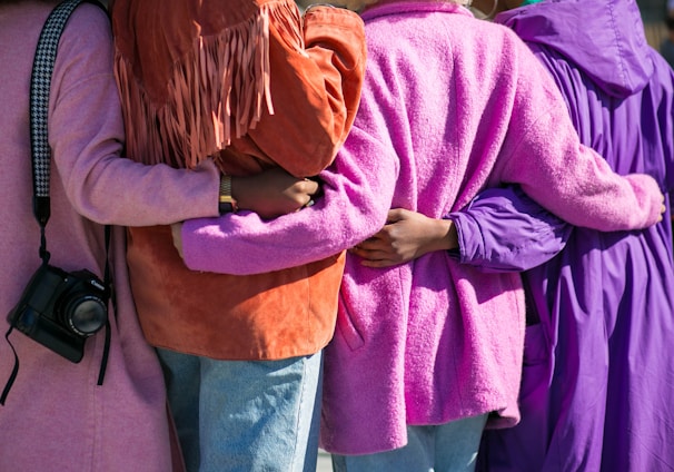 four person holding each others waist at daytime