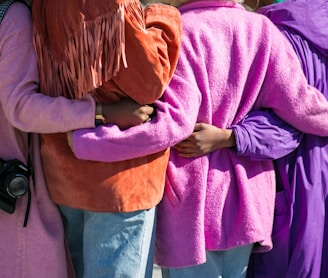 four person holding each others waist at daytime