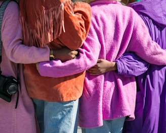 four person holding each others waist at daytime