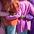 four person holding each others waist at daytime