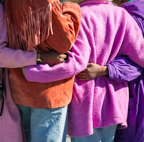 four person holding each others waist at daytime