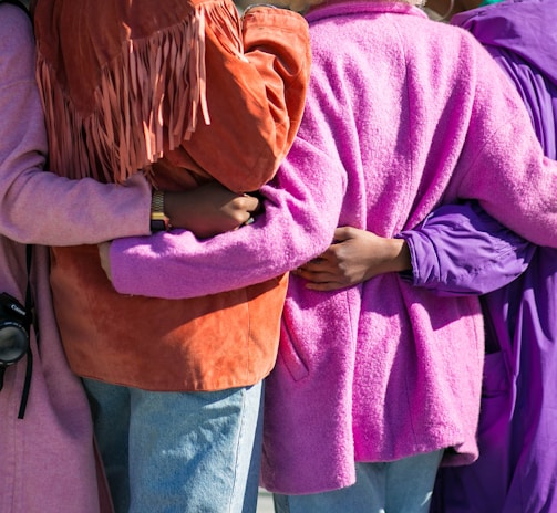 four person holding each others waist at daytime