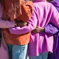 four person holding each others waist at daytime