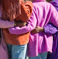 four person holding each others waist at daytime