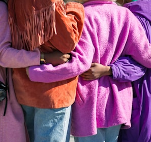 four person holding each others waist at daytime