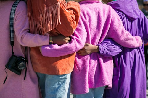 Group of people with hands around each others backs, like the sense of community user-generated content fosters