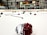 An indoor ice hockey rink with various pieces of hockey equipment scattered on the ice, including helmets and sticks. Banners and flags adorn the walls above the rink, and a scoreboard displays the end of a game.